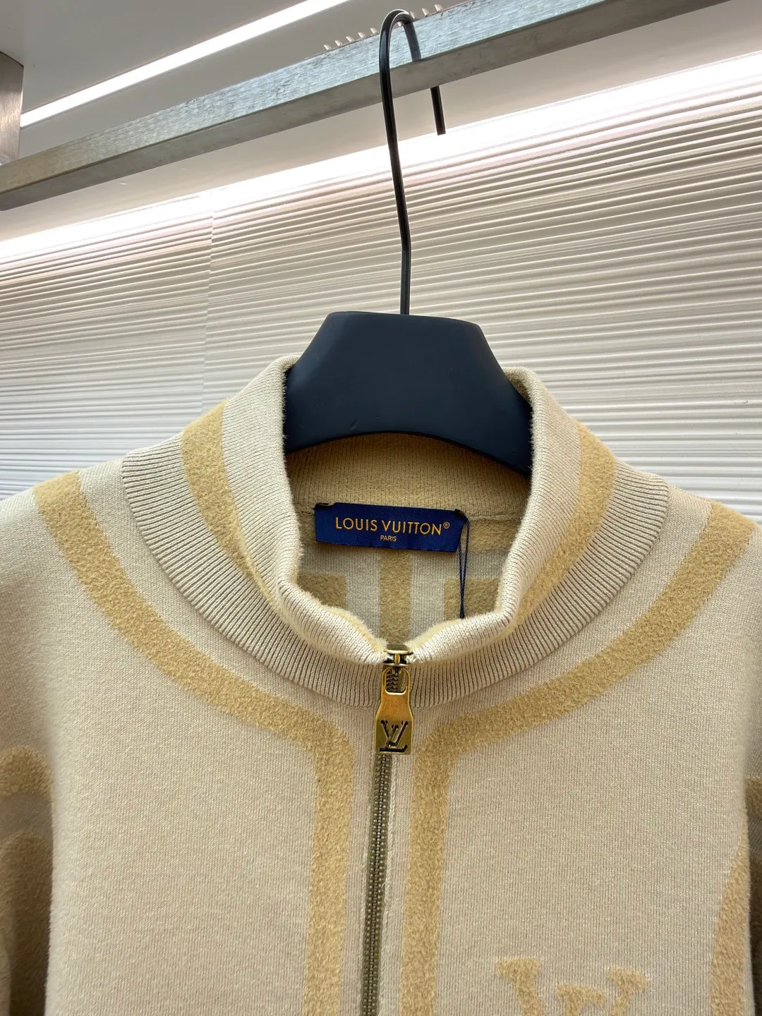 LOUIS VUITTON two-color splicing intarsia zipper jacket ●Original version: purchased and developed at 20700 ●Item number: 1681968-C15 ●Fabric: nylon fabric ●Technology: intarsia production ●Color: khaki ●Version: fitted version ●Weight: about 1020 grams ●Size: XS-S-M-L ●Description: Made of 43% nylon, 32% cotton and 25% viscose blended fabric, which has both comfort and stiffness. The designer used two-tone intarsia technology to allow contrasting color strips to run through the sleeves and body, forming a smooth visual extension. Different areas create subtle three-dimensional texture effects by changing knitting density and stitching methods. The chest is decorated with a delicate intarsia LV logo, and the Vuitton word is presented in elegant font on the back, showing brand recognition in every detail. The collar, cuffs and hem made of rib knitting technology not only enhance the stability of the silhouette, but also echo the overall design language. The front placket features a smooth zipper closure and practical slip pockets on both sides for added functionality. The entire piece perfectly interprets the exquisite aesthetics of sports and leisure style through the ingenious combination of fabric texture and craftsmanship details. The overall wiring is straight and delicate, the fabric is comfortable and soft, and the color is consistent without color difference. It can be matched with the same style to create a fashionable look and control various occasions. Customized accessories, complete with three standards, same style for men and women!